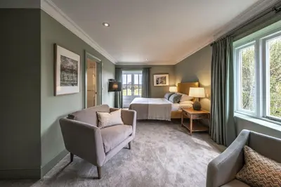 a hotel room with a bed and a couch and a chair at The Crown Inn in Stoke by Nayland