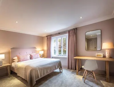 a bedroom with a bed and a table and a mirror at The Crown Inn in Stoke by Nayland