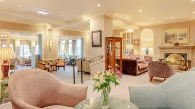 a living room filled with furniture and a fireplace at Wentworth Hotel in Aldeburgh