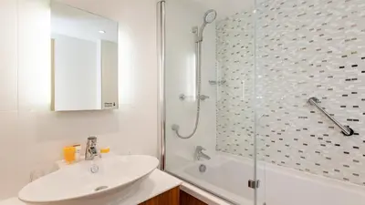 a white bathroom with a sink and a shower at Wentworth Hotel in Aldeburgh