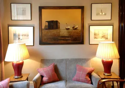 a living room with a couch and two lamps at Wentworth Hotel in Aldeburgh