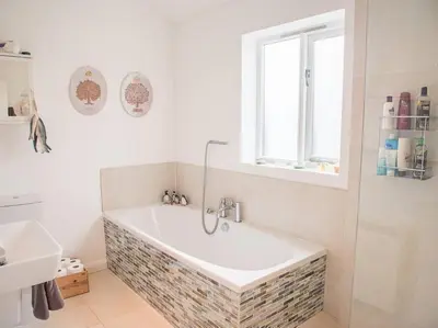 a bath tub in a bathroom with a window at Honeybee Cottage, Orford in Orford
