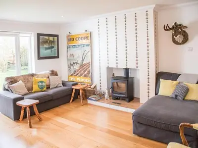 a living room with a couch and a fireplace at Honeybee Cottage, Orford in Orford