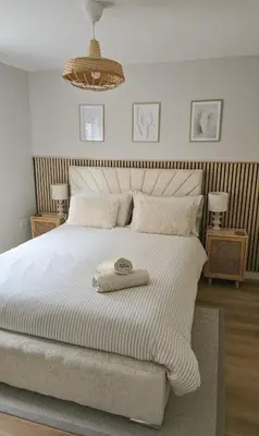 a bedroom with a white bed with a towel on it at Welcome Home in Royston
