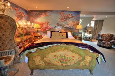 a bedroom with a large bed with a painting on the wall at Strattons in Swaffham