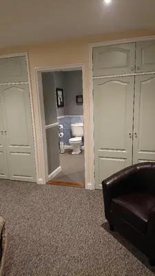 a room with a bathroom with a toilet and a couch at Grove House Hotel in Woodbridge