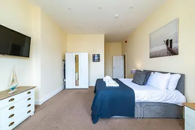 a bedroom with a large bed and a tv at Greyfriars in Clacton-on-Sea