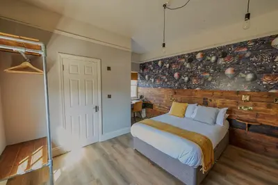 a bedroom with a bed and a wall of pots and pans at The White Horse Hotel in Leiston