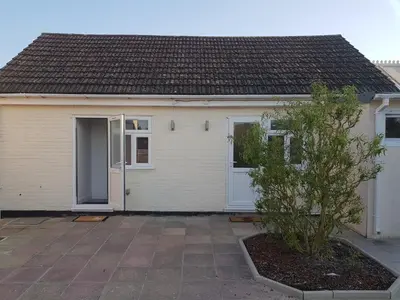 a white house with a door and a tree at Stanwell Stansted Airport in Takeley
