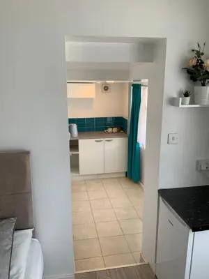 a kitchen with white cabinets and a tile floor at Stanwell Stansted Airport in Takeley