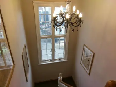 a chandelier in a hallway with a window at The Rifle Volunteer in Ware