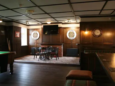 a dining room with a table and chairs and a television at The Rifle Volunteer in Ware