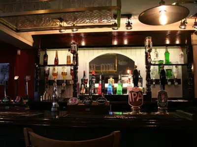 a bar with a lot of bottles on the wall at The Rifle Volunteer in Ware