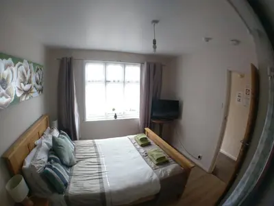 a bedroom with a bed in front of a window at The Rifle Volunteer in Ware