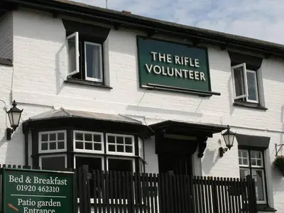 a white building with a sign that reads the little volunteer at The Rifle Volunteer in Ware