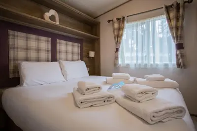a bedroom with a white bed with towels on it at Mersea Island by Away Resorts in Colchester