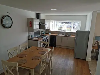 a kitchen with a table with chairs and a refrigerator at Mersea Island by Away Resorts in Colchester