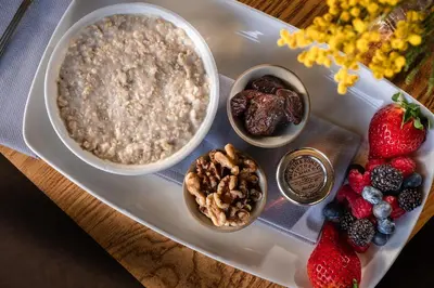 a plate of food with oatmeal and fruit on a table at The Cricketers Clavering in Clavering