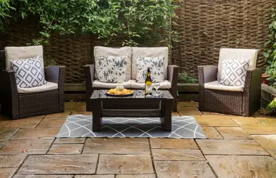 two chairs and a coffee table on a patio at Oak Cottage in Thorndon