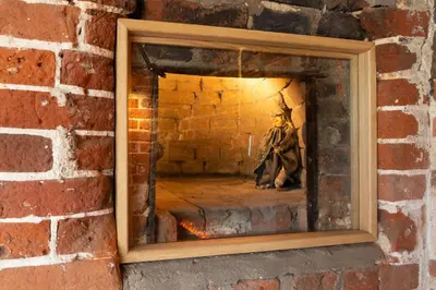 a mirror in a brick wall with a person in the reflection at Honeysuckle Cottage in Thornham Magna