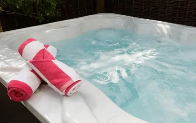 a stuffed teddy bear sitting in a hot tub at Honeysuckle Cottage in Thornham Magna