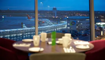 a table at an airport with a view of an airport at Holiday Inn Southend by IHG in Southend-on-Sea