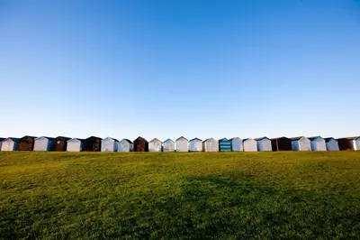 a row of beach huts in a field of grass at Holiday Inn Southend by IHG in Southend-on-Sea