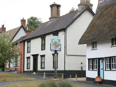 a white building with a sign in front of it at Ploughman's in Eye