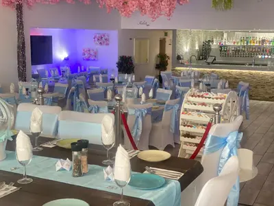 a banquet hall with blue tables and white chairs at The Royal Hotel - Clacton On Sea in Clacton-on-Sea