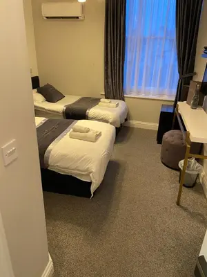 a hotel room with two beds and a window at The Royal Hotel - Clacton On Sea in Clacton-on-Sea