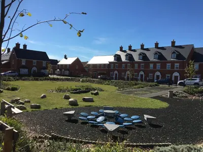 a garden with a fire pit in the middle of a yard at Detached Coach House in Colchester