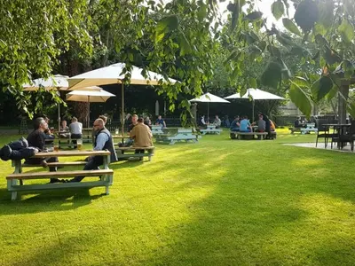 a group of people sitting on benches in a park at Bedingfeld Arms in Swaffham