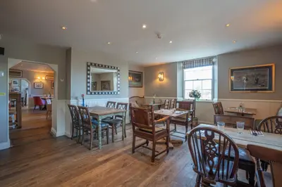 a dining room with wooden tables and chairs at Bedingfeld Arms in Swaffham