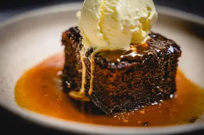 a piece of chocolate dessert with ice cream on top at The Bull Inn in Woolpit