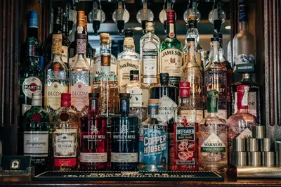 a large group of bottles of alcohol on a bar at The Bull Inn in Woolpit