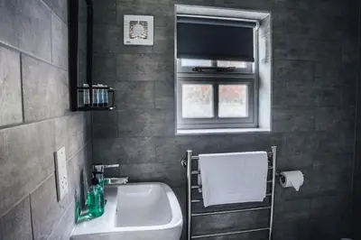 a bathroom with a sink and a mirror and a window at The Bull Inn in Woolpit
