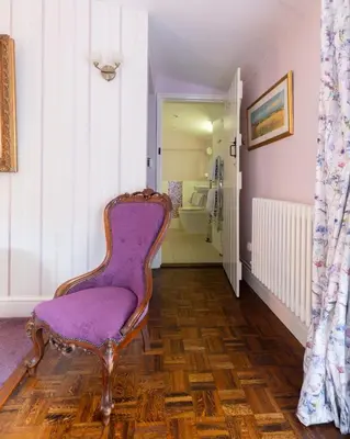 a purple chair in a hallway with a bathroom at Frogs Hall B&B in Eye