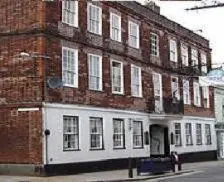a large brick building on the corner of a street at Swan Hotel in Harleston