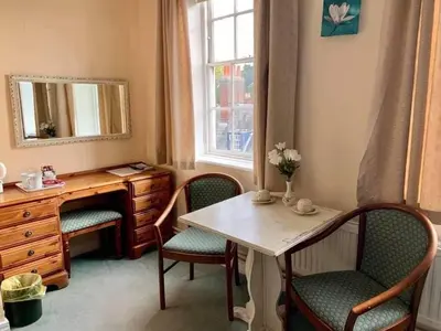 a room with a desk and a table and chairs at Swan Hotel in Harleston