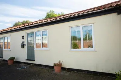 a white house with a green door and windows at PERFECT BUSINESS ACCOMMODATION at SIDINGS FARM - Luxury Cottage Accommodation - Fully equipped & Self Catering in Pidley