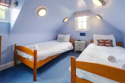 two beds in a room with blue walls at 2 Ogilvie Lodge in Thorpeness