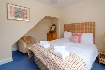 a bedroom with a bed with towels on it at 2 Ogilvie Lodge in Thorpeness