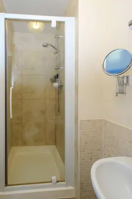 a bathroom with a shower with a tub and a sink at 2 Ogilvie Lodge in Thorpeness
