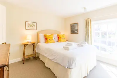 a bedroom with a bed and a window at 5 Coastguard Cottages in Aldeburgh