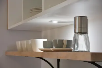 a shelf with cups and saucers on it at Milk Parlour in Spexhall