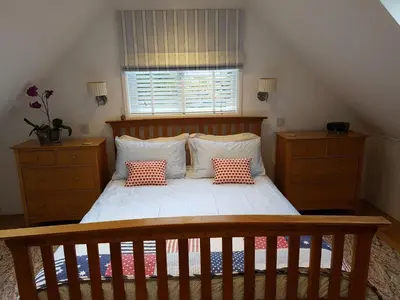 a bedroom with a bed with two pillows on it at Wellrose Barn in Hertford