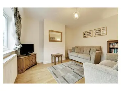 a living room with a couch and a tv at 18 Pilgrim’s Way in Thorpeness