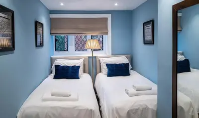 two beds in a room with blue walls at Beautiful Country House Apartment in Newmarket