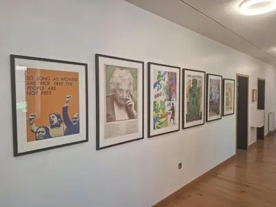 a group of pictures on a wall in a gallery at Newnham College - University of Cambridge in Cambridge