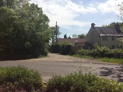 an empty road in front of a house at Blyth Green Stable in Long Stratton